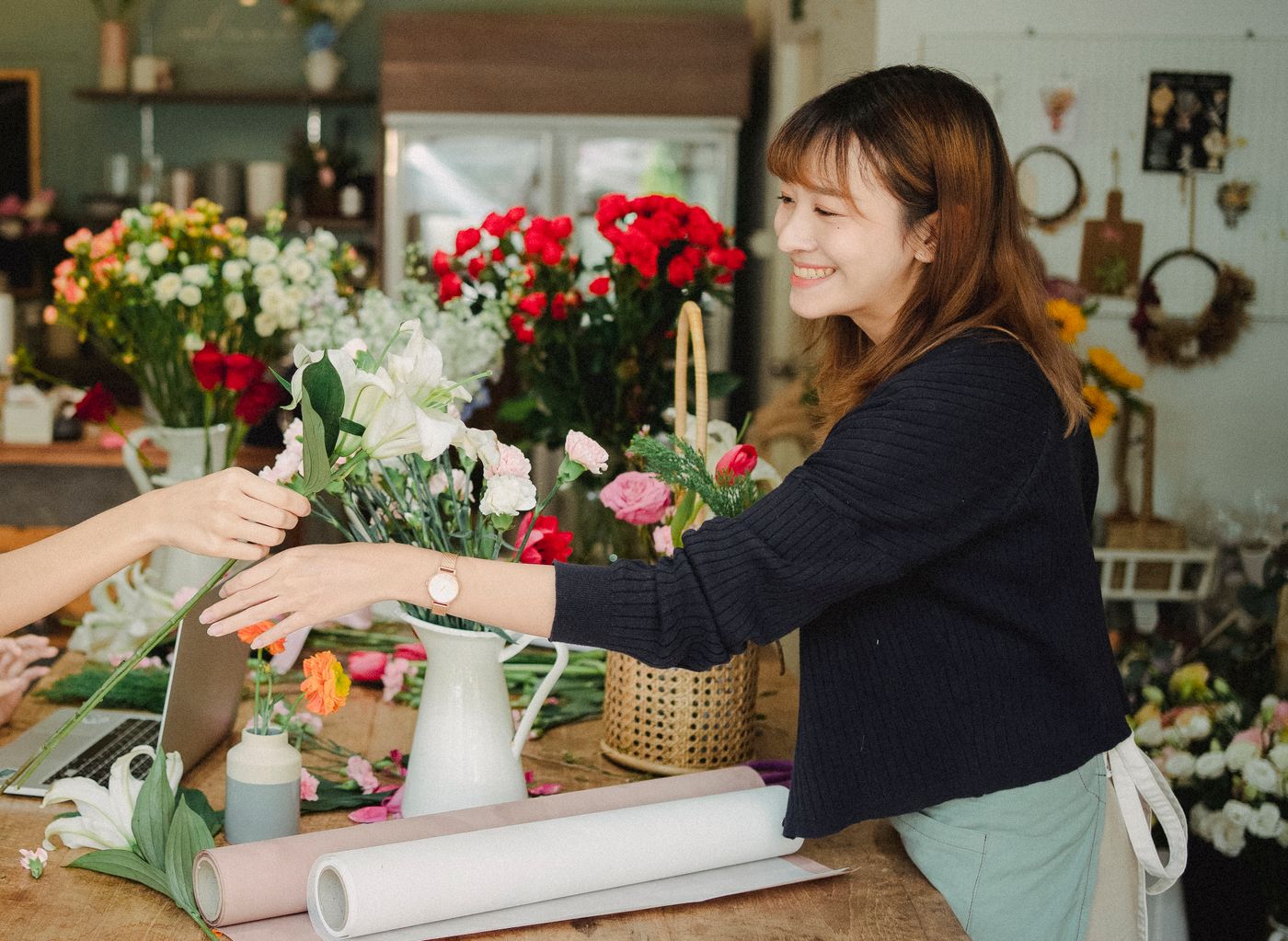 カウンター越しに花束を手渡している店主