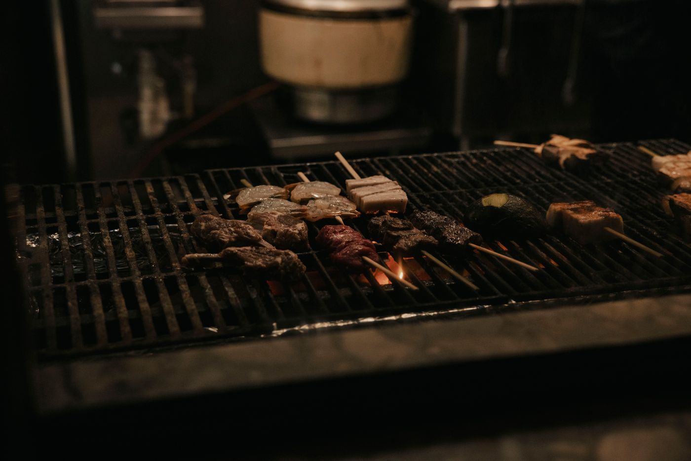 焼き台の下で赤く熾った炭と、その上に並ぶ串