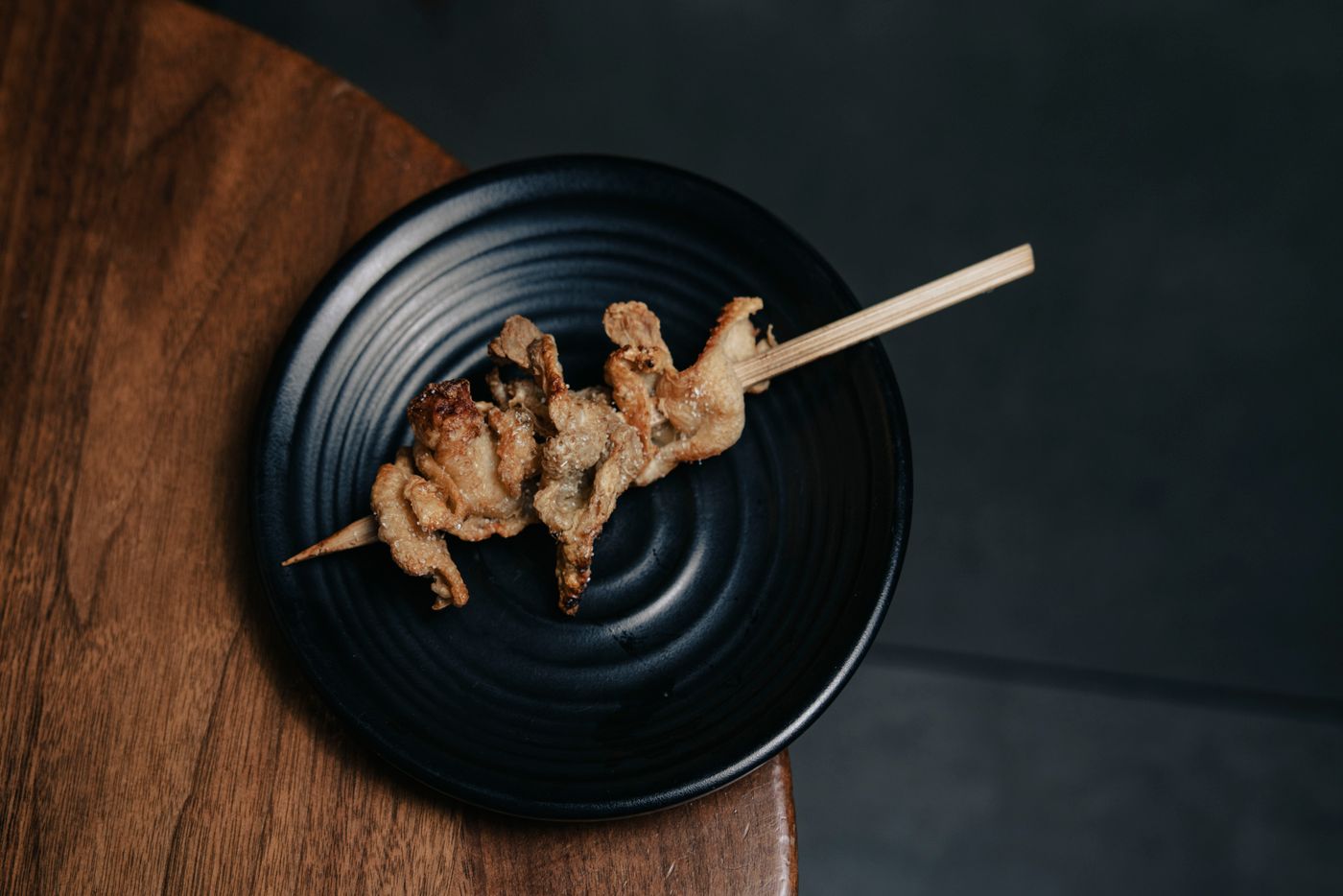 黒い平皿に置かれた串
