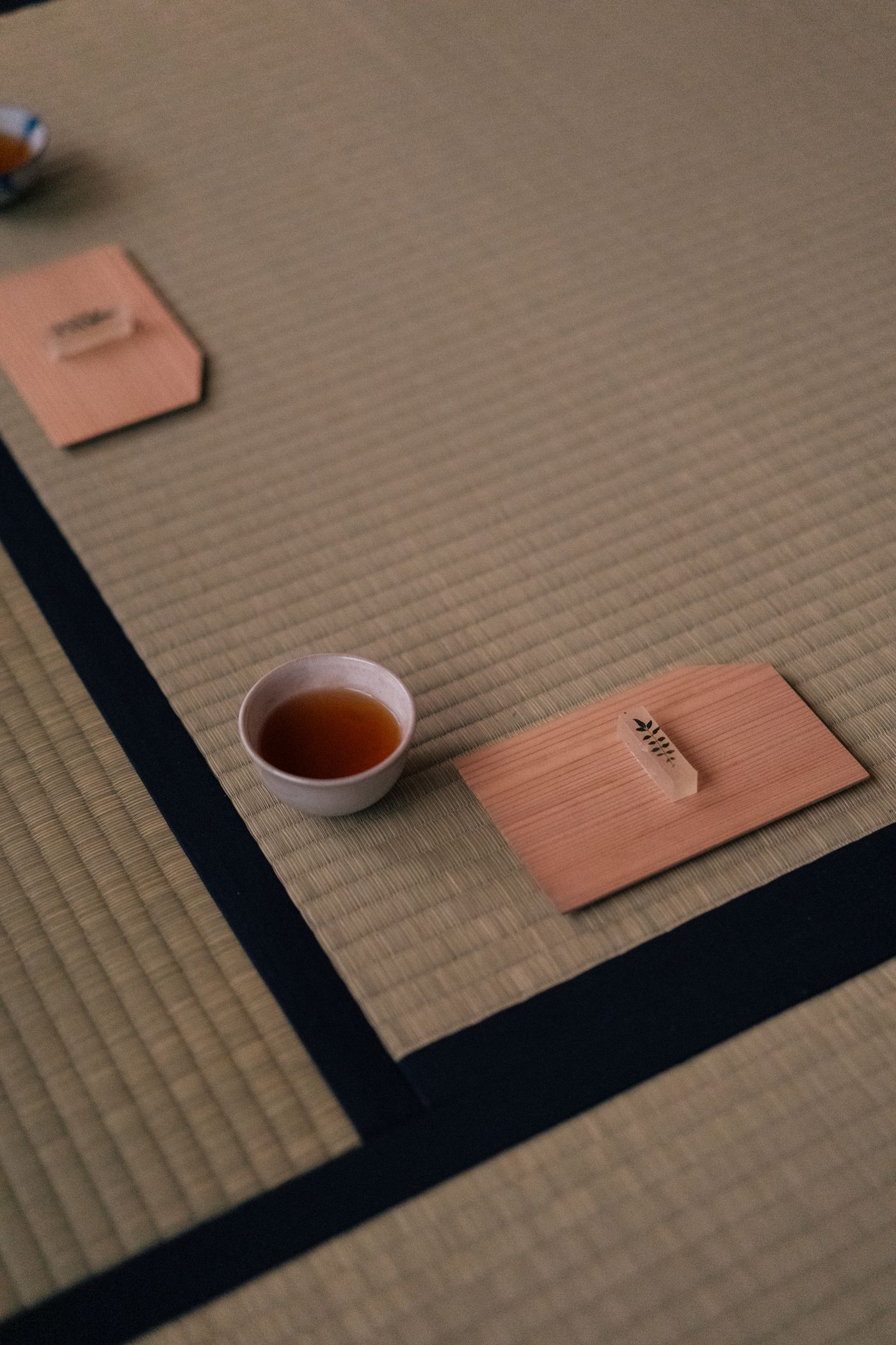 畳の上に置かれた湯呑みと、杉板にのせた菓子