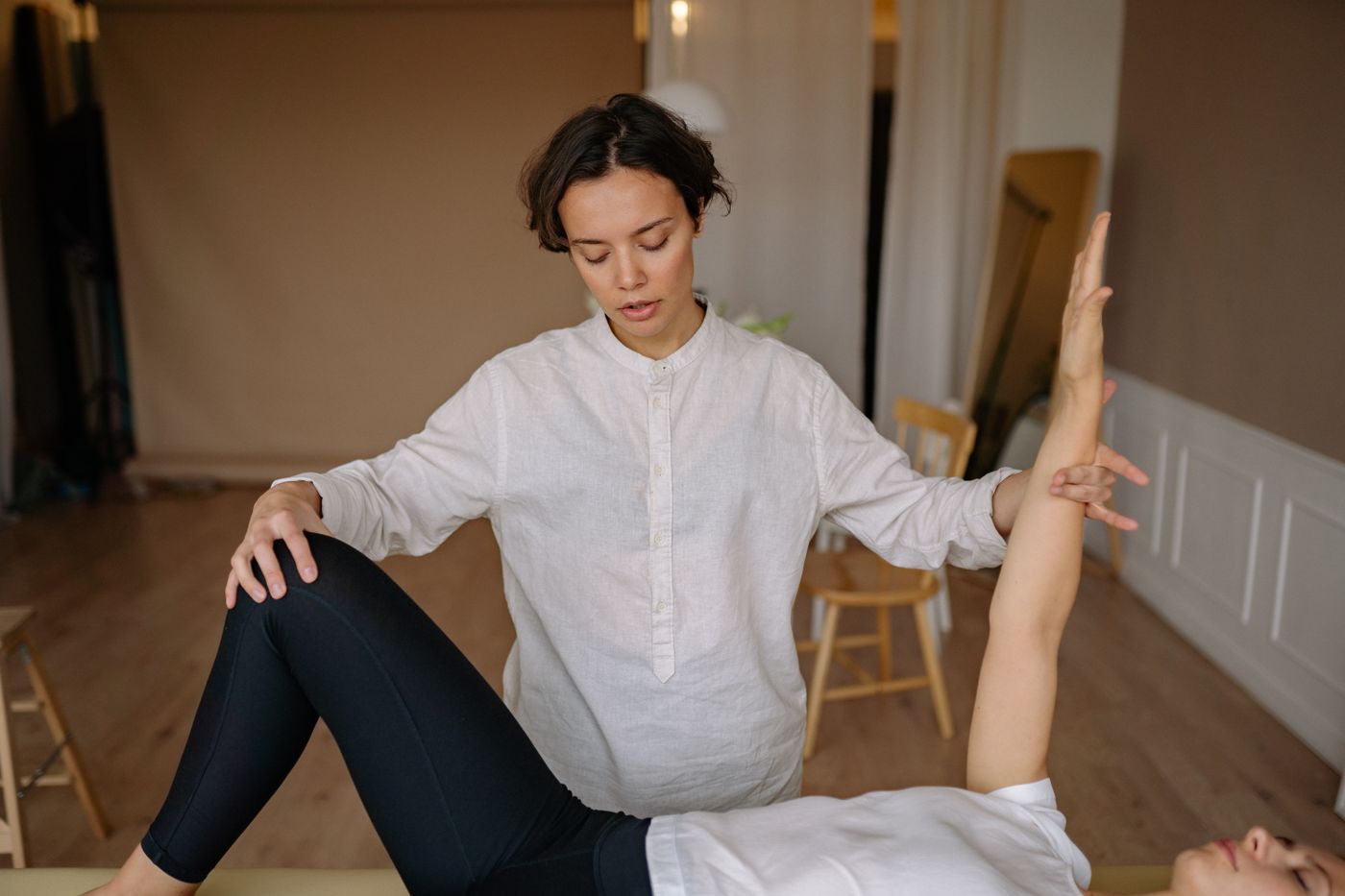 木の床と椅子が見える、明るい院内で施術をしているところ