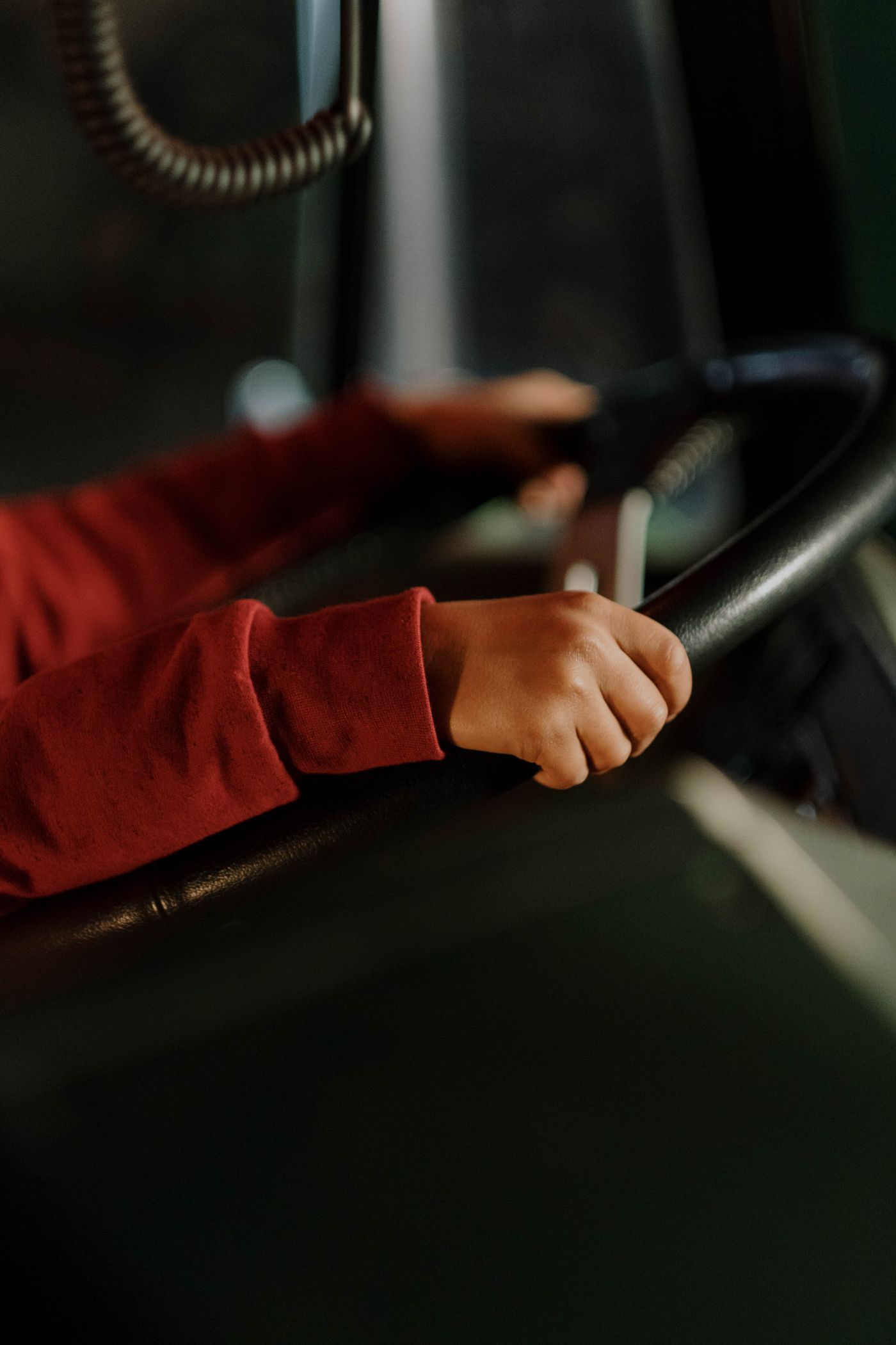 運転席でハンドルを両手で握っている手元